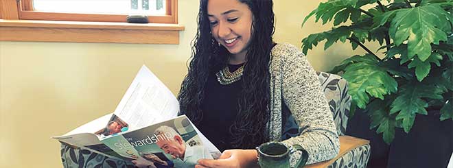 Elise Romero reading Everence Everyday Stewardship magazine